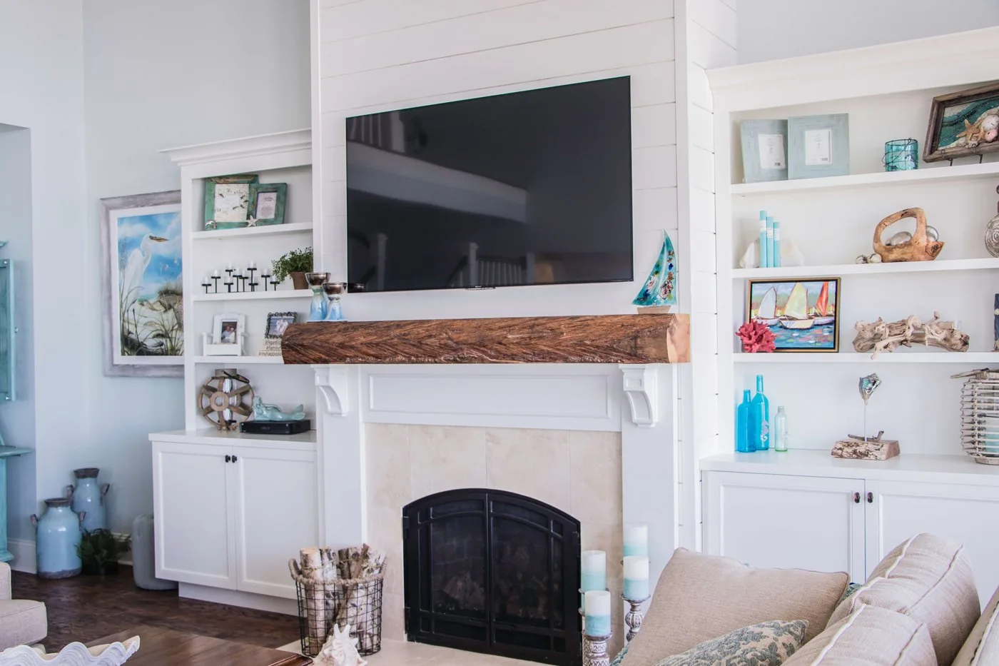 A built-in shelving wall and painted cabinetry flanking a fireplace