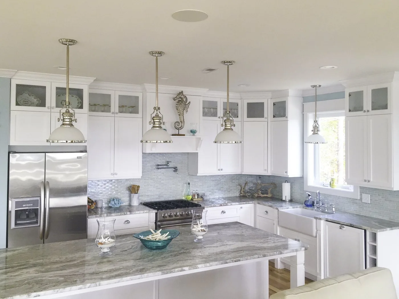 An FFT kitchen with a large island, glass upper cabinets, and stone counters