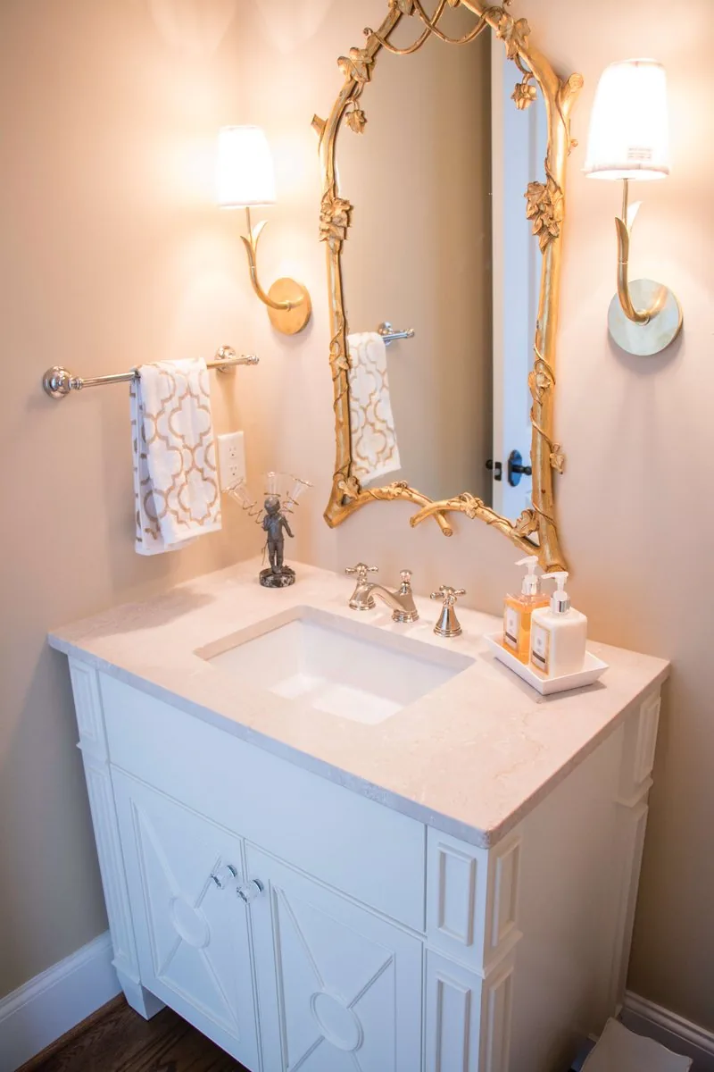 A small vanity with a shaped face frame and a marble top
