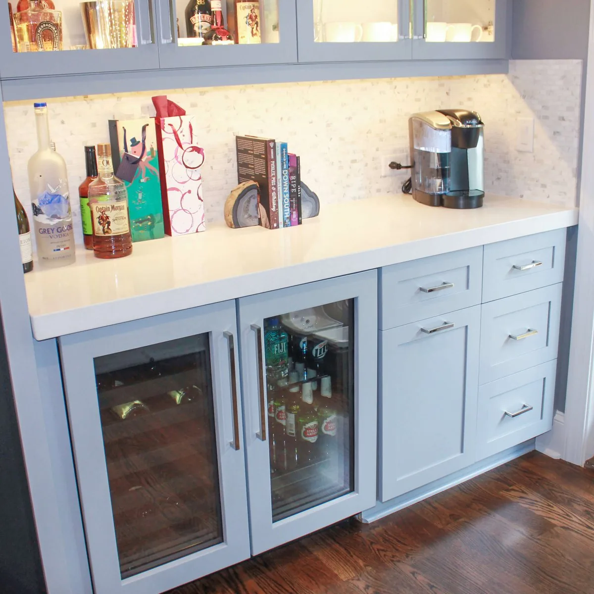 A home bar with glass door cabinets and a stone counter