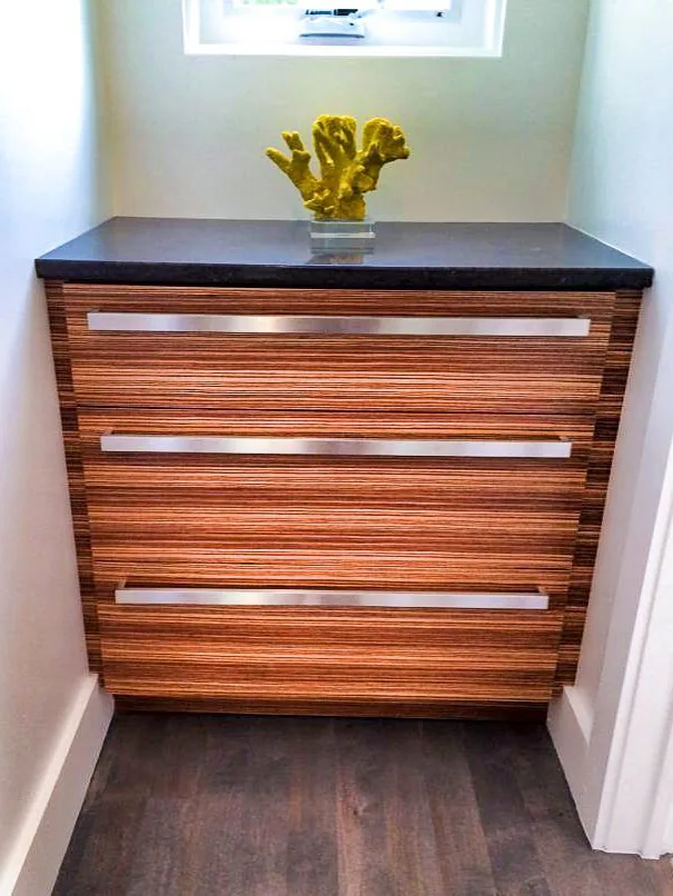 A hardwood chest of drawers with inset metal pulls