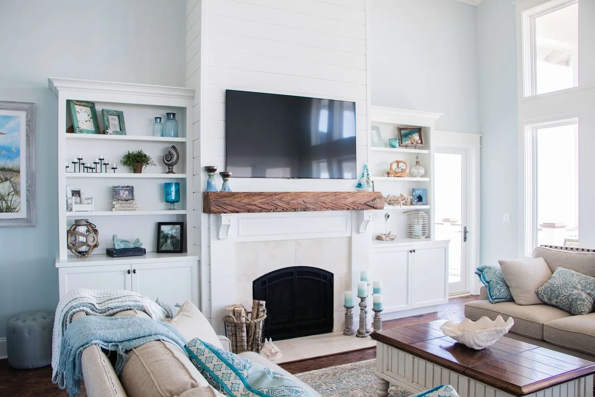 Built-in shelving and cabinets flanking a fireplace with a timber mantel