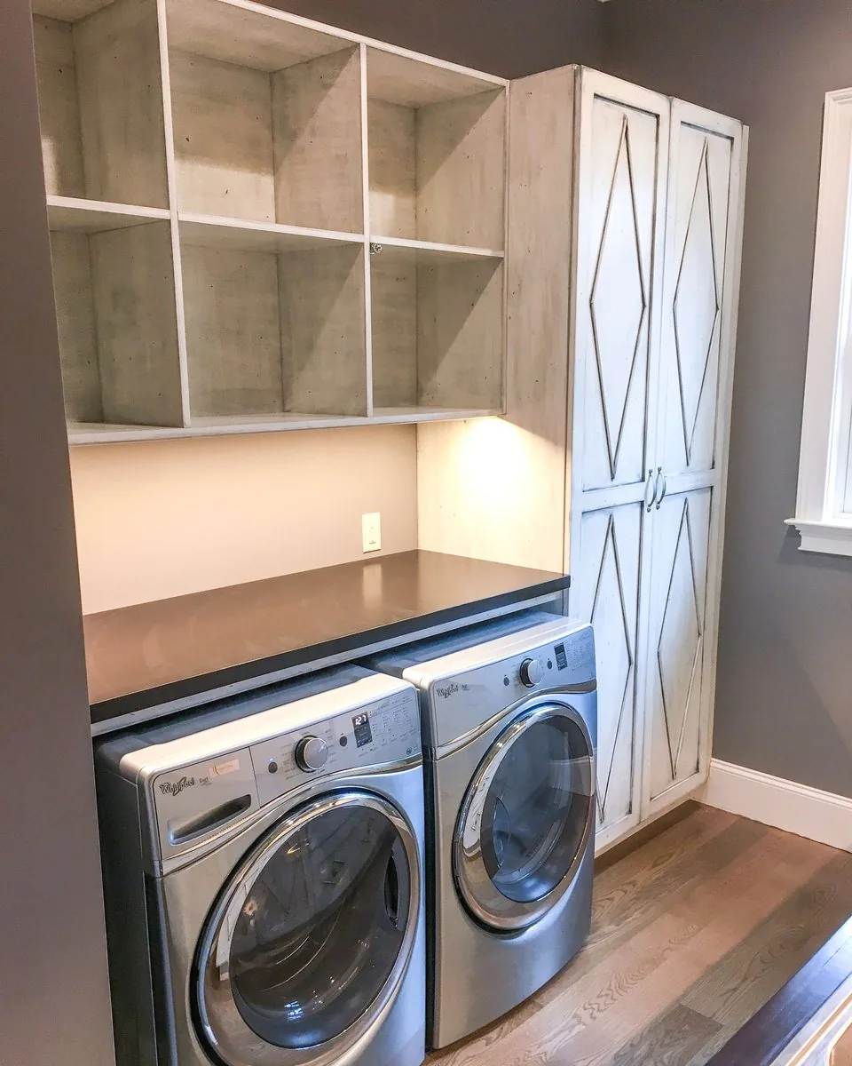 A laundry room with open cubbies and tall paneled doors