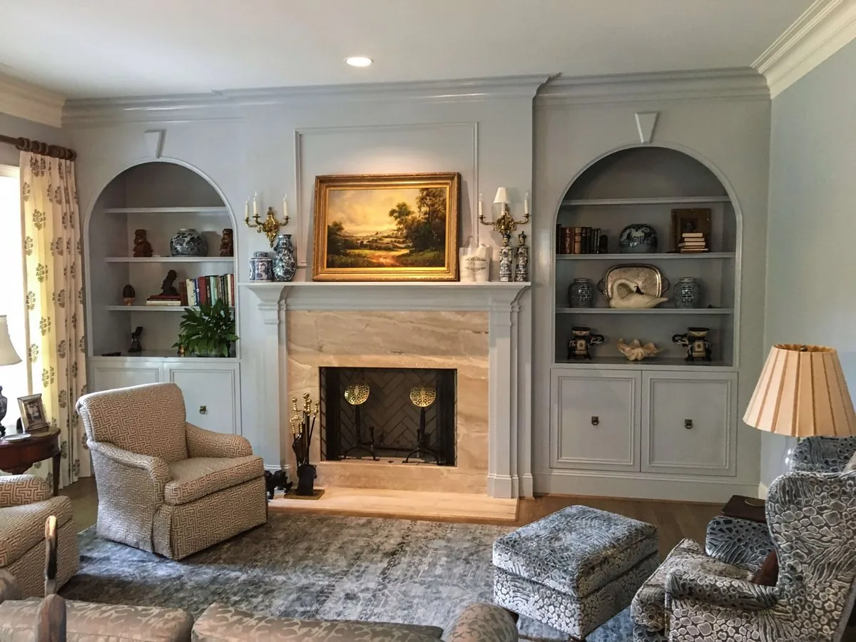 Arched built-in display shelving beside a fireplace