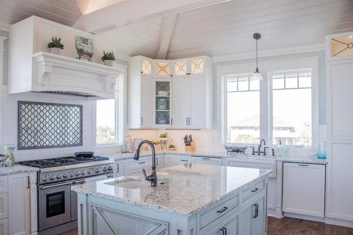 A coastal kitchen with a hooded range and a granite island